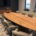 Maatwerk ovale teakhouten vergadertafel met bijpassend dressoir in een moderne boardroom met uitzicht op het water